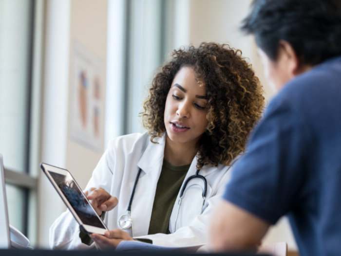 dr and patient looking at laptop